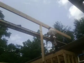 Carpenter setting a ridge beam over a new addition frame — Ice Dam Removal by Roofing Brothers in Vacherie