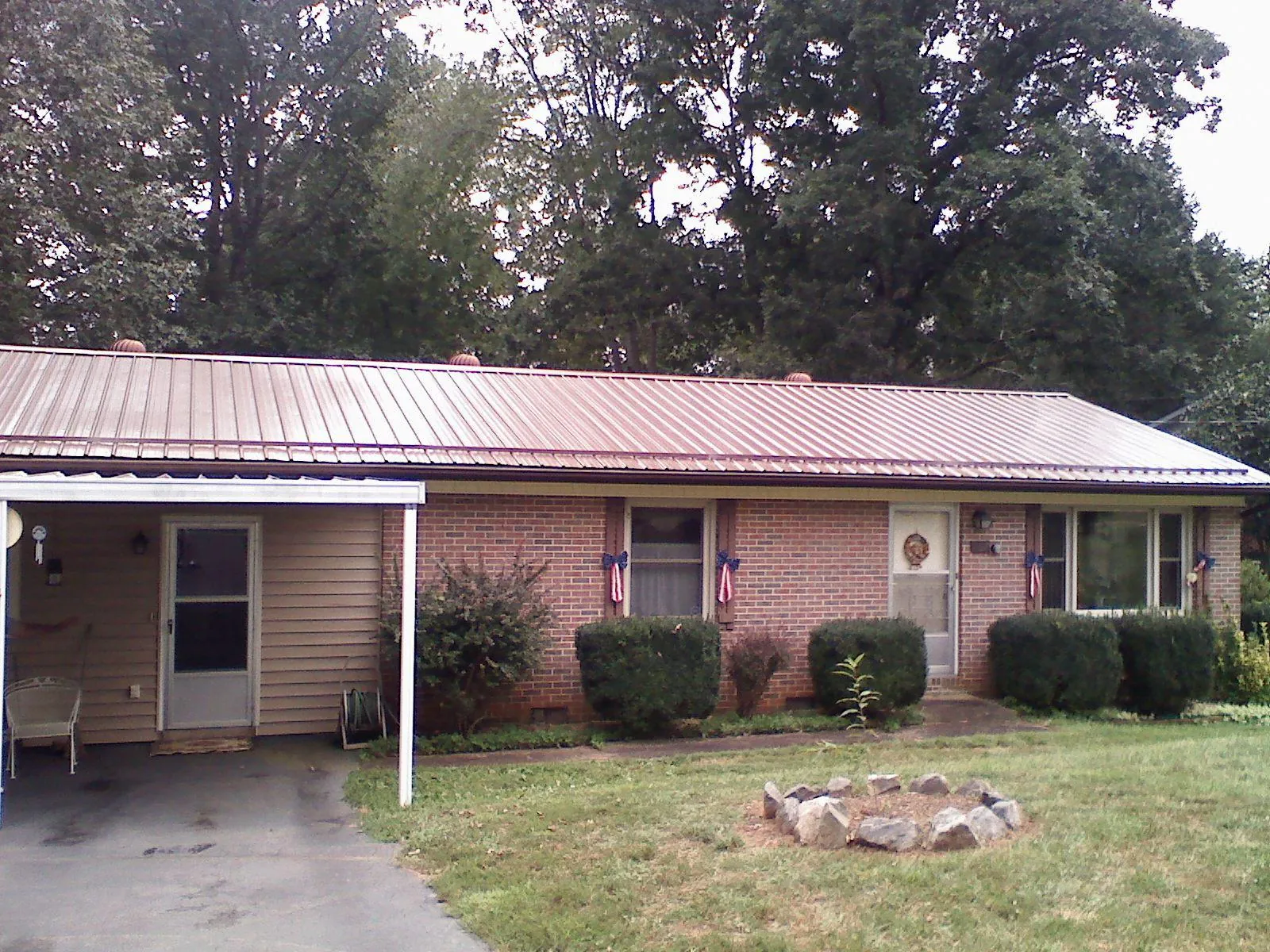 Bronze metal roof and carport on a brick ranch home — Roof Repair work by our crew in Vacherie